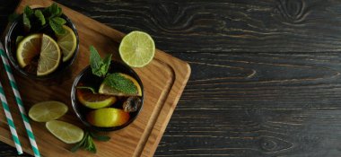 Tahta zemin üzerinde Küba Libre bardakları olan bir tahta.