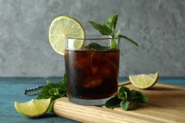 Tahta masanın üzerinde bir bardak Küba Libre 'si olan bir tahta.