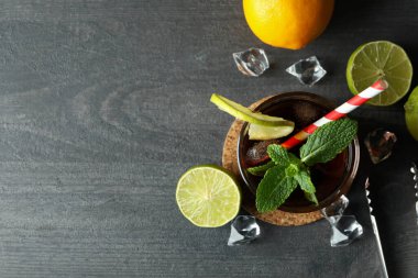 Bir bardak Küba Libre 'si ve içindekiler karanlık masada, metin için yer var.