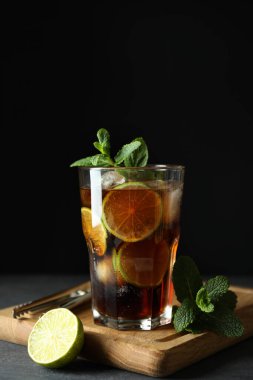 Karanlık arka plana karşı Küba Libre camı olan tahta