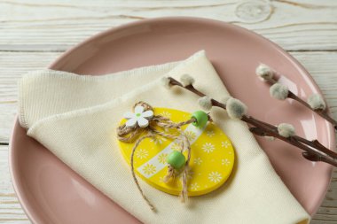 Ahşap Paskalya yumurtası, mutfak peçetesi ve ahşap arka planda kedi derisi olan tabaklar.