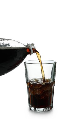 Kola şişeden bir bardağa doldurulur, beyaz arka planda izole edilir.