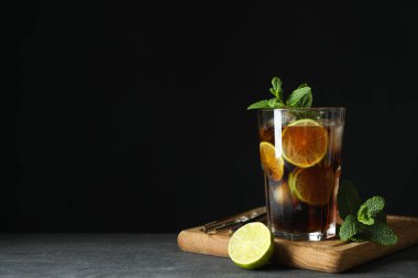 Karanlık arka plana karşı Küba Libre camı olan tahta