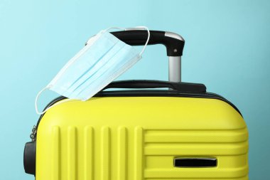 Mavi arka planda tıbbi maskeli seyahat çantası
