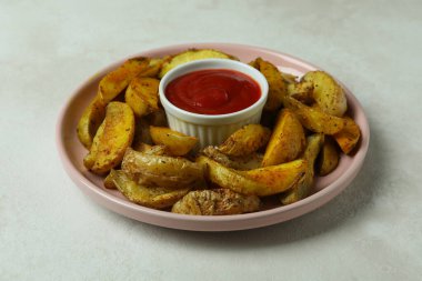 Beyaz desenli arka planda kızarmış patates ve sos tabağı.