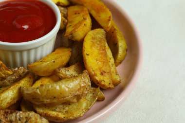 Beyaz desenli arka planda kızarmış patates ve sos tabağı.