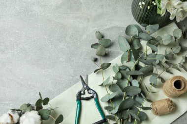 Okaliptüs, çiçek ve pamuklu gri masa.