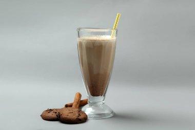 Bir bardak çikolatalı milkshake, kurabiyeler ve tarçın.