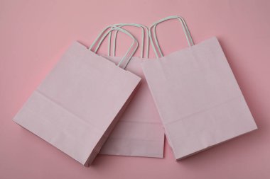 Pembe zemin üzerinde boş kağıt torbalar, metin için boşluk