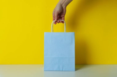 Sarı arka planda kadın el çantası.