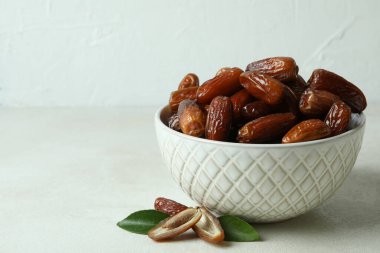 Beyaz desenli masa üzerinde kurutulmuş tarihler olan kase