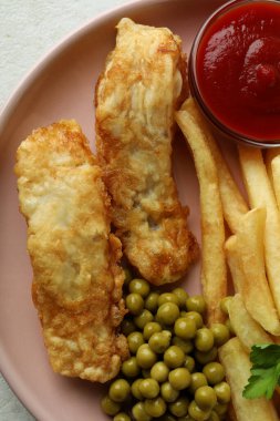 Kızarmış balık ve patates kızartması, bezelye ve ketçap, yakın çekim.