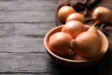 Tahta zemin üzerinde taze soğan ve mutfak havlusu olan bir kase.