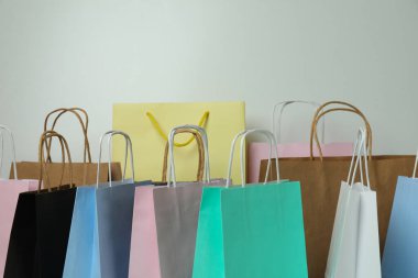 Beyaz arkaplanda farklı renkli kağıt torbaları var.