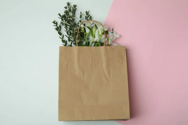 Blank paper bag with flowers on two tone background