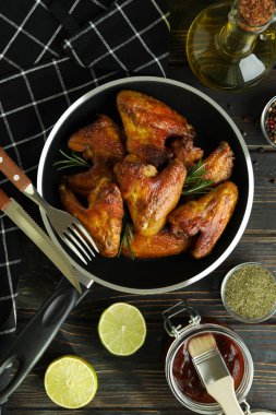 Ahşap arka planda fırında tavuk kanadı olan lezzetli yemek kavramı.