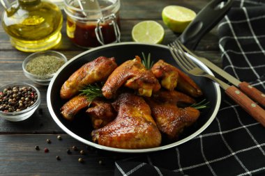Ahşap arka planda fırında tavuk kanadı olan lezzetli yemek kavramı.