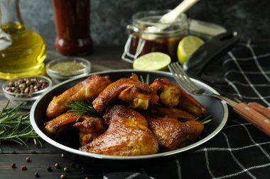 Ahşap arka planda fırında tavuk kanadı olan lezzetli yemek kavramı.