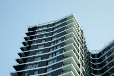 Açık mavi gökyüzüne karşı modern çok katlı bina