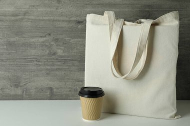 Gri desenli arka plana karşı yankı torbası ve kağıt bardak