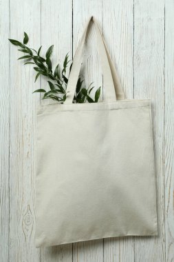 Beyaz ahşap arka planda dallı eko çanta