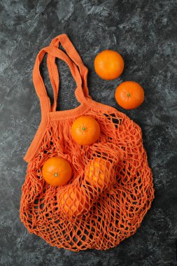 Siyah dumanlı arka planda mandalinalı dizgi çantası