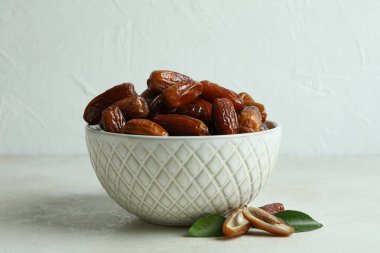 Beyaz desenli masa üzerinde kurutulmuş tarihler olan kase