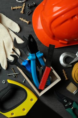 Koyu ahşap arka planda farklı inşaat araçlarıyla İşçi Bayramı kavramı