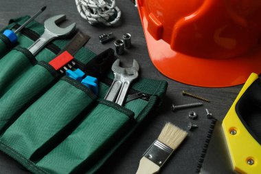 Koyu ahşap arka planda farklı inşaat araçlarıyla İşçi Bayramı kavramı