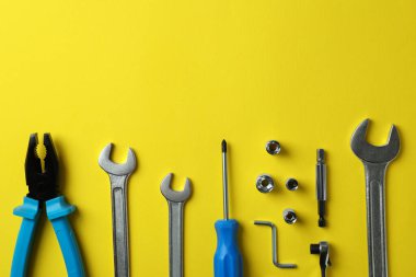 Sarı arkaplan üzerinde çalışan araçlarla düz uzandı