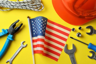 Sarı zemin üzerinde farklı aksesuarlar bulunan Mutlu İşçi Bayramı kavramı