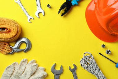 Sarı zemin üzerinde farklı aksesuarlar bulunan Mutlu İşçi Bayramı kavramı