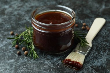 Barbekü sosu, baharatlar ve siyah dumanlı arka planda fırça