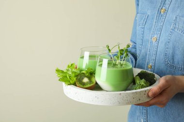 Kadın meyve suyu ve malzemelerle dolu tepsiyi tut.