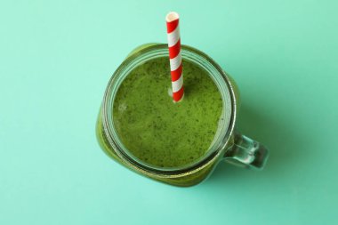 Yeşil smoothie ve nane arkaplanlı saman kavanozu