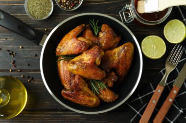 Ahşap arka planda fırında tavuk kanadı olan lezzetli yemek kavramı.