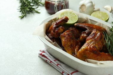 Beyaz desenli masada fırında tavuk kanadı ile pişirme tepsisi.