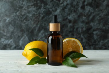 Beyaz ahşap masada yağlı ve limonlu bir şişe.