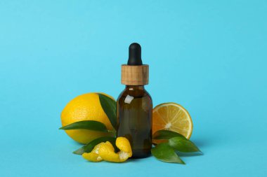 Mavi arka planda yağlı ve limonlu damlacık şişesi