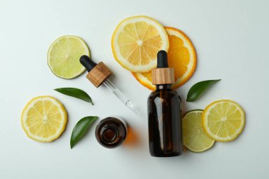 Beyaz arka planda yağ ve narenciye dilimleri olan damlalar.