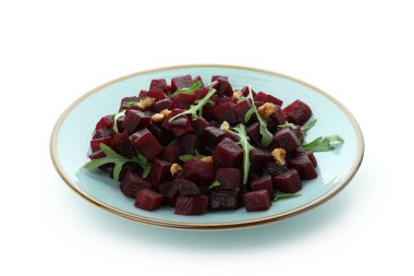 Beyaz arka planda taze pancar salatası olan tabak.