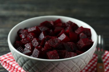 Pancar salatası, çatal ve mutfak havlusuyla ahşap arka planda kase