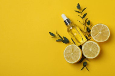 Sarı zemin üzerinde limon yağı olan doğal kozmetik kavramı