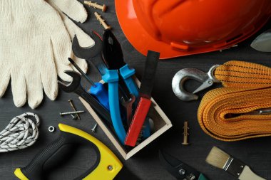 Koyu ahşap arka planda farklı inşaat araçlarıyla İşçi Bayramı kavramı