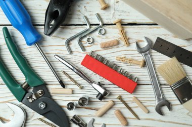 Beyaz ahşap arka planda farklı çalışma araçları, kapat