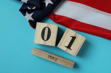 Mavi zemin üzerinde 1 Mayıs olan Amerikan bayrağı ve ahşap takvimi