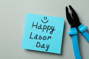 Metin Mutlu İşçi Bayramı ve gri arkaplanda pense