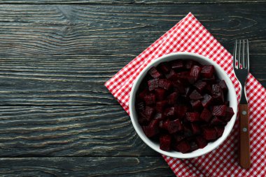 Pancar salatası, çatal ve mutfak havlusuyla ahşap arka planda kase