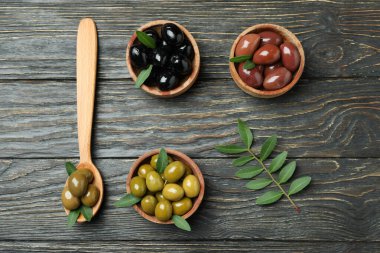 Farklı zeytin ve kaşık kâseleriyle ahşap kaplanmış zeytinler.