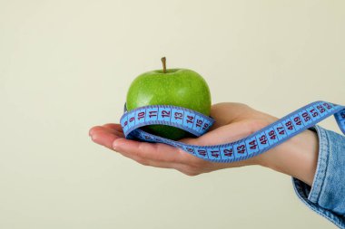 Bej arka planda mezurası olan kadın el ele tutuşma elması